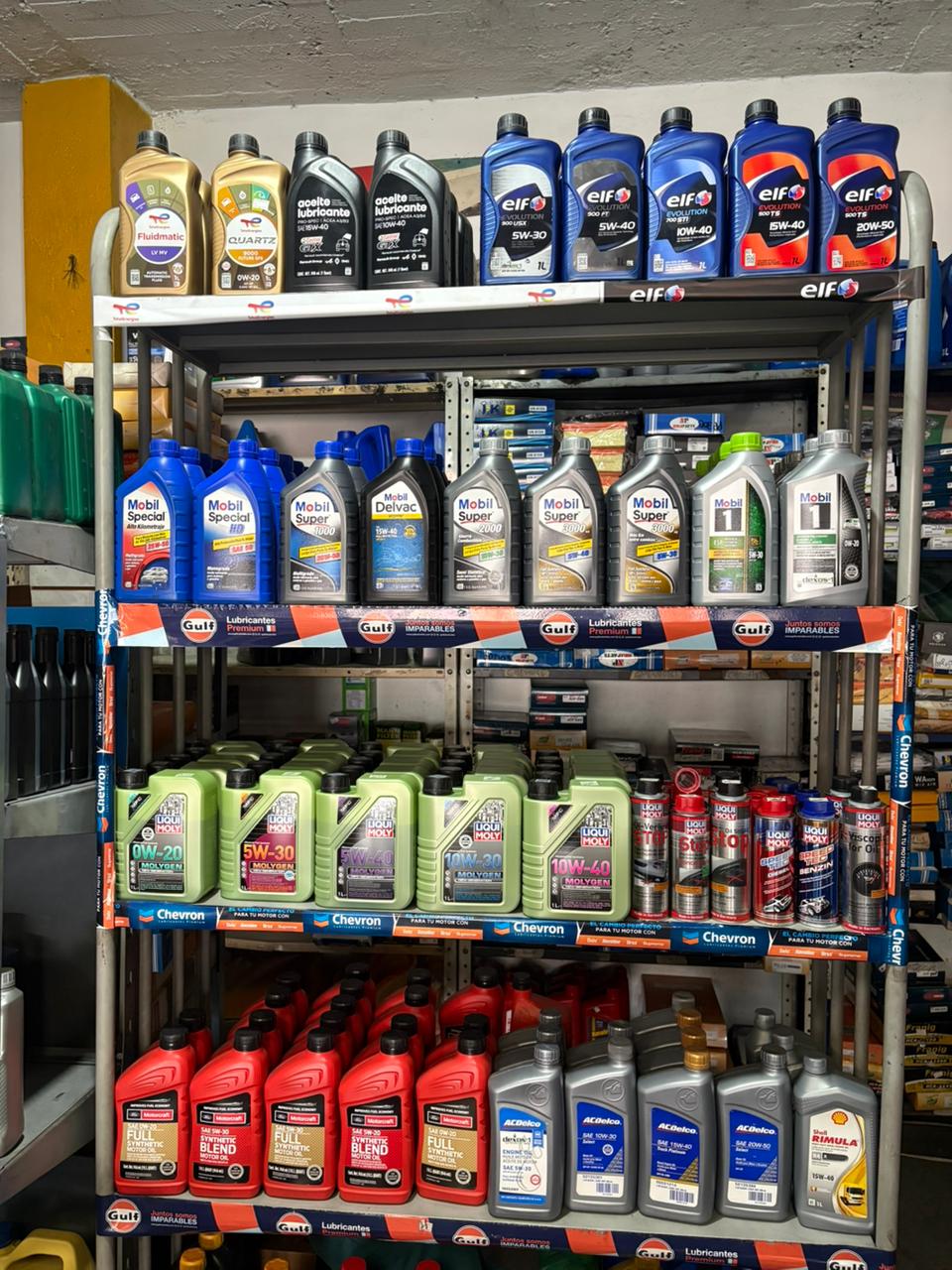 Cambio de aceite para autos en Ibagué en Lubriambalá: estantería con aceites Mobil, TotalEnergies y Elf